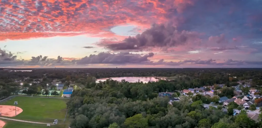 Aerial view of a serene landscape in Casselberry, FL, with a stunning sunset, showcasing the area served by Termite Lawn and Pest's comprehensive services.