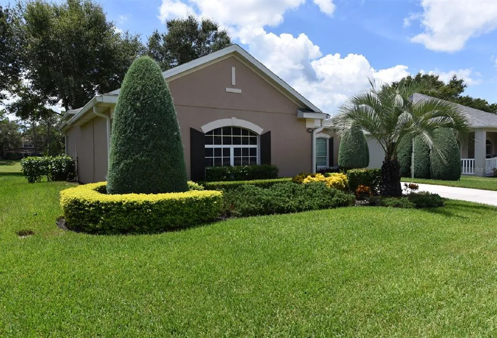 Well-maintained lawn and landscape in front of a house, showcasing the lawn care services offered by Termite Lawn and Pest in Clermont.