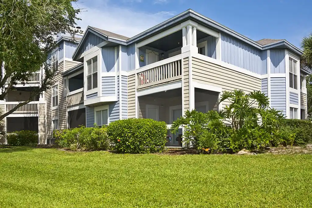 Residential building with a lush green lawn and well-maintained shrubs, showcasing the benefits of professional College Park lawn care services.