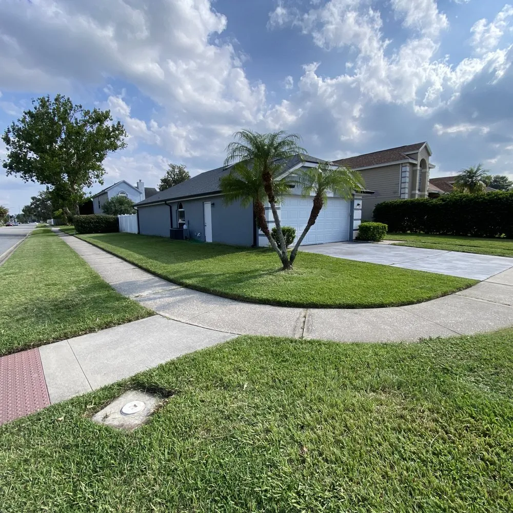 A beautifully maintained lawn in a suburban neighborhood, showcasing the expert lawn care services that we provide in Lake Nona.