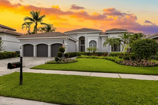 A beautiful, well-manicured lawn and garden in front of a house at sunset, showcasing the results of professional lawn care services in Mount Dora.