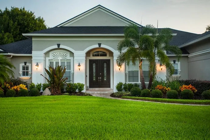 Well-maintained lawn in front of a beautiful house, showcasing the effectiveness of Orlando lawn care services.