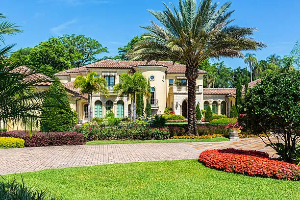 Beautifully maintained lawn and garden in front of a luxurious home, showcasing the results of premier Windermere lawn and landscape services.