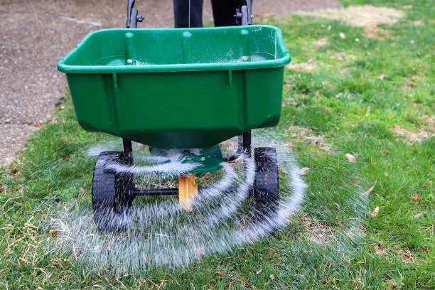 A professional lawn spreader distributing fertilizer on a green lawn as part of Orlando lawn care services.