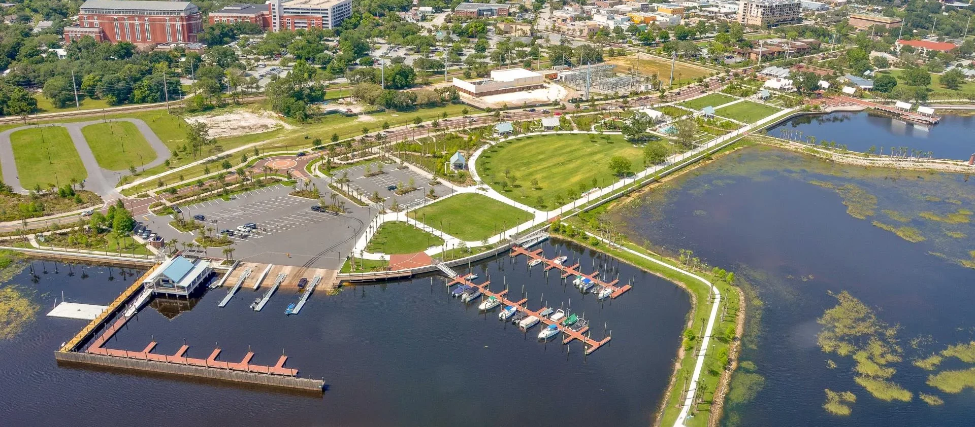 Aerial view of a waterfront area in Kissimmee, showcasing well-maintained landscapes and docks, highlighting the comprehensive services provided by Termite Lawn and Pest.