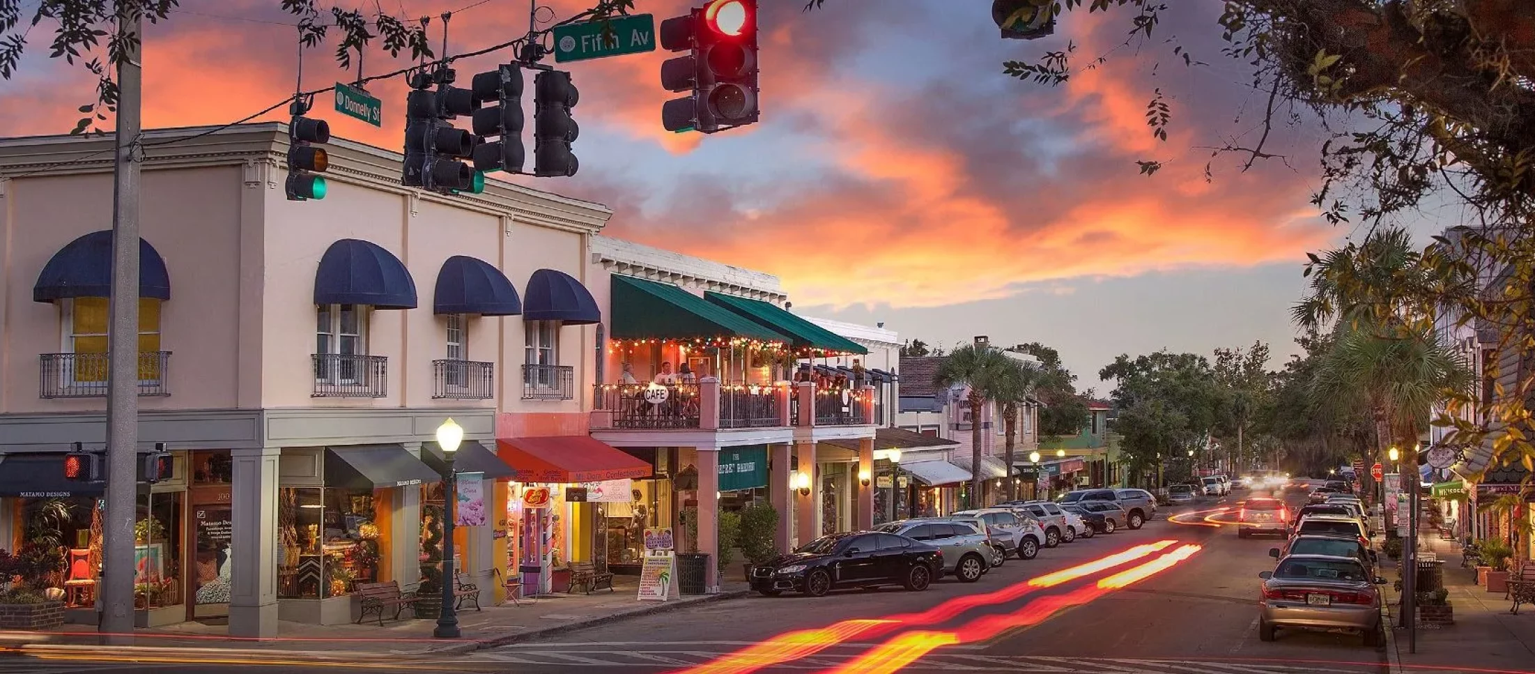 A vibrant street scene in Mount Dora at sunset, with charming storefronts and restaurants, highlighting the community's beauty and the importance of maintaining properties with professional services.