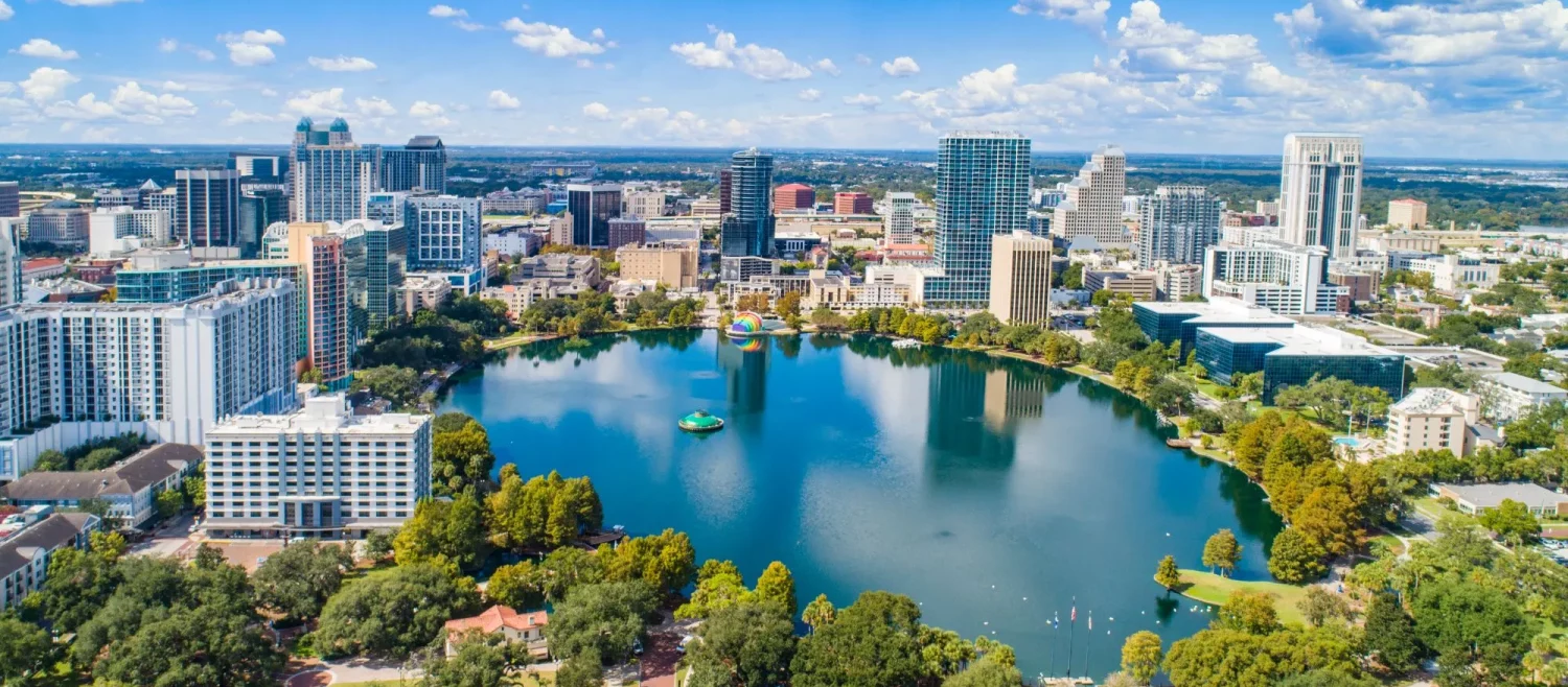 Aerial view of downtown Orlando with beautiful green spaces and a serene lake, showcasing the comprehensive services available in the community.